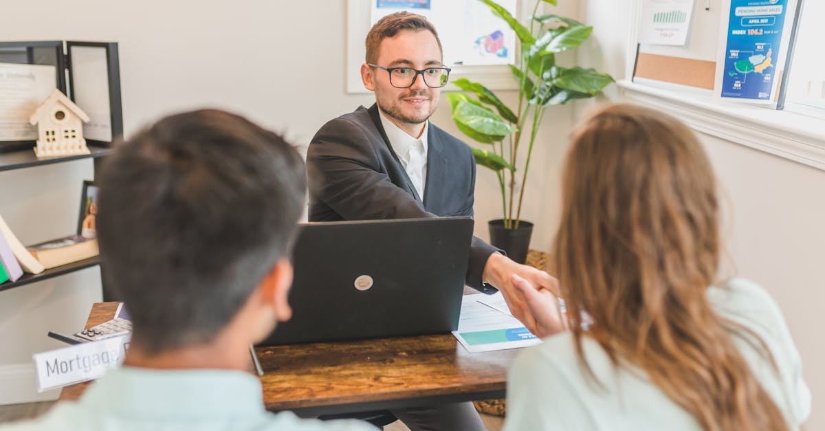 A mortgage broker meeting clients in an office, discussing agreements and loans.